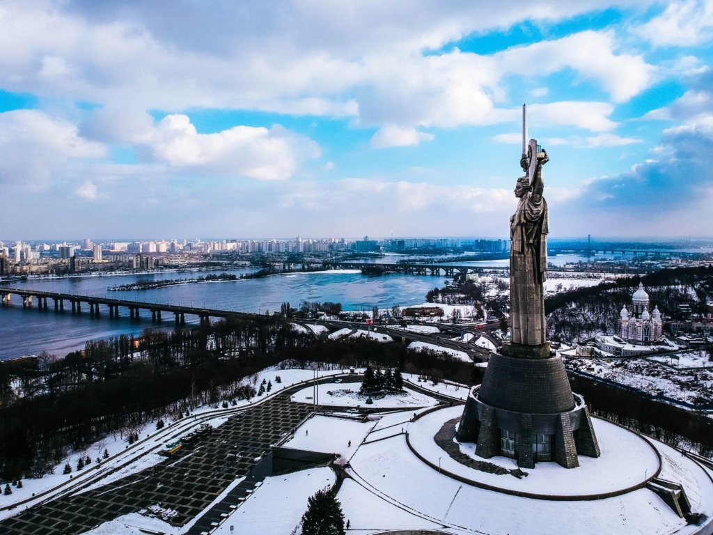 brown concrete statue under white cloudy sky
