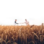 two persons standing on wheat field