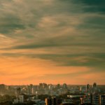 city skyline under cloudy sky during sunset