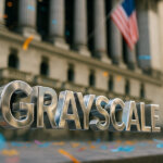 “GRAYSCALE” letters hover midair in front of the NYSE facade as colorful confetti floats through bright daylight.