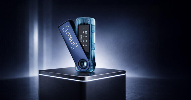 Ledger Nano S Plus hardware crypto wallet displayed open on a pedestal with internal components visible, representing its security model, recovery features, supported assets, and fees in review