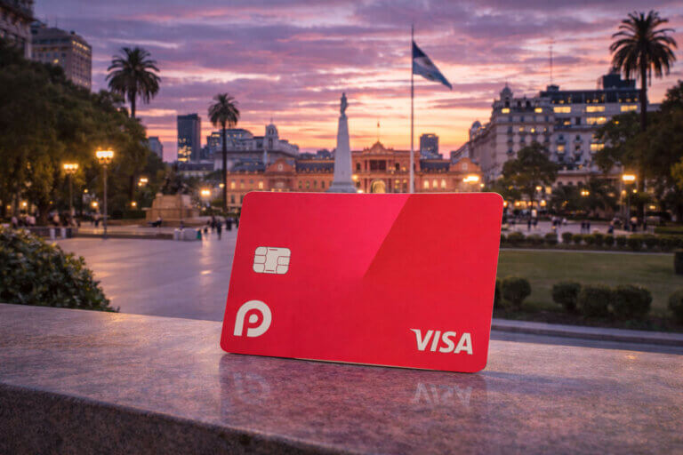 Red crypto debit card with Visa branding displayed in a city square at sunset, representing the RedotPay crypto card review