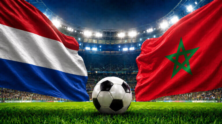 Netherlands and Morocco flags face off above a soccer ball in a packed stadium, representing a FIFA World Cup prediction market matchup.