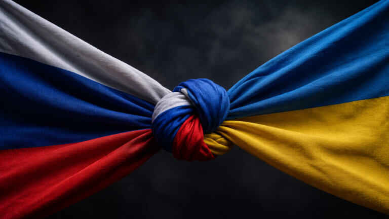 Russian and Ukrainian flags tied in a tight knot, symbolizing ongoing ceasefire negotiations and uncertainty over a future Russia-Ukraine peace agreement.