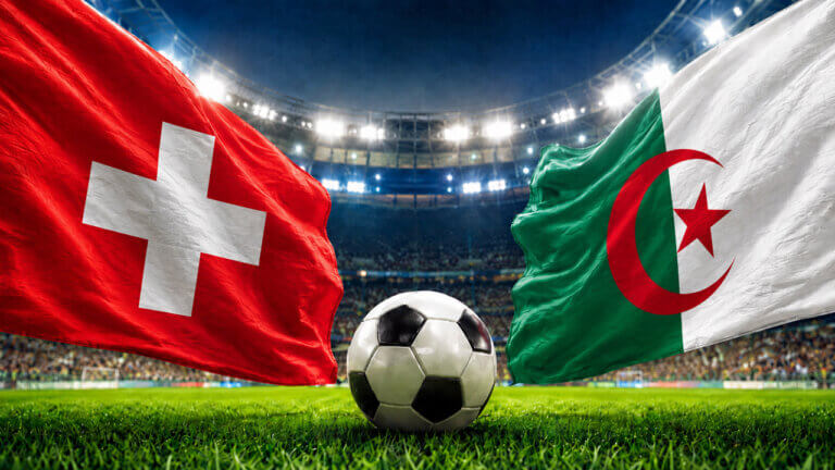 Switzerland and Algeria flags face off above a soccer ball in a packed stadium, representing a FIFA World Cup prediction market matchup.