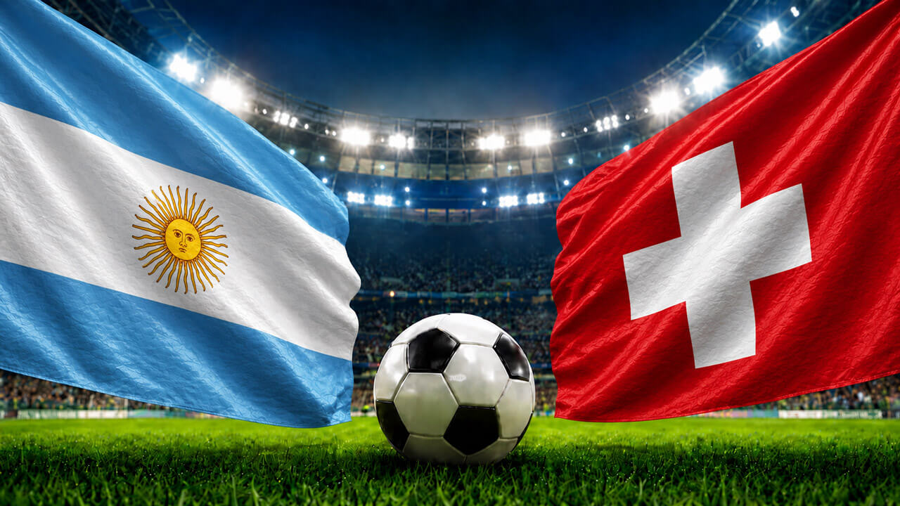 Argentina and Switzerland flags wave over a soccer ball on a stadium grass pitch under bright floodlights.