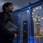 Crypto startup founder carrying a laptop and prototype equipment toward a glass EU compliance checkpoint overlooking a European financial district.
