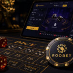 Close-up cinematic casino scene featuring a Roobet branded chip on a dice game table with red dice, stacked chips, and a tablet displaying a Roobet-style dice betting interface.